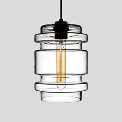 Clear ribbed glass pendant with stacked rings, lit against grey