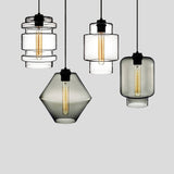 Three clear and smoke pendants hung together at staggered heights