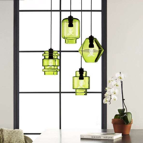 Green pendants in three shapes hung in a black window frame