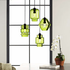 Green pendants in three shapes hung in a black window frame