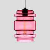 Pink ribbed glass pendant with stacked rings and a filament bulb