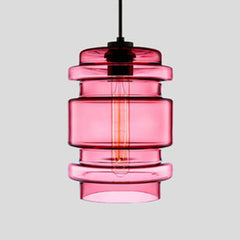 Pink ribbed glass pendant with stacked rings and a filament bulb