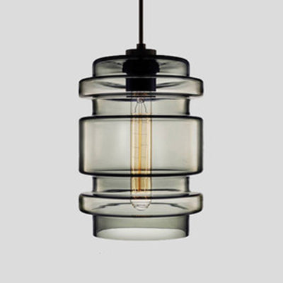 Smoke grey ribbed glass pendant with stacked rings, shown lit