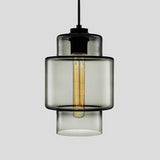 Smoke grey stepped glass pendant with a wide upper band, lit