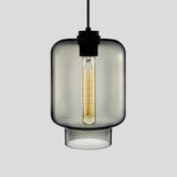 Smoke grey tapered glass pendant with a black cap, shown lit