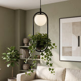 Black hoop planter pendant with a glass globe and trailing ivy
