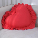 Decorative seating accessory featuring heart shaped pillow with ruffle edge