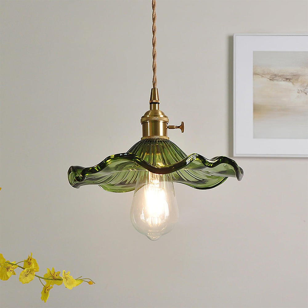 Green scalloped glass hibiscus shade on a brass holder with a filament bulb