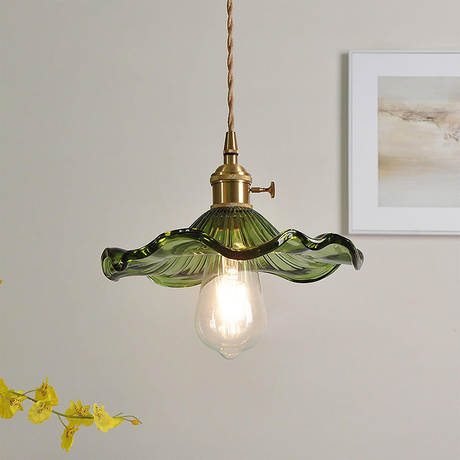 Green scalloped glass hibiscus shade on a brass holder with a filament bulb