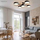 Black modern circular LED ceiling light in an open-plan dining and living space with balcony doors