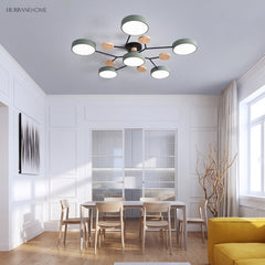 Sage green modern circular LED ceiling light in a bright panelled dining room with timber chairs