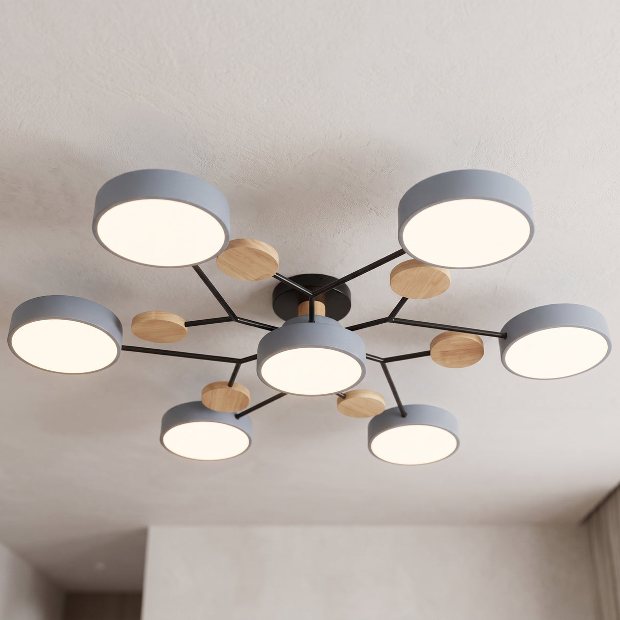 Modern circular LED ceiling light with grey discs and wood accents mounted on a plain ceiling
