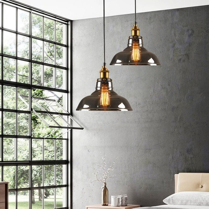 Two amber dome pendants lit in a bedroom beside a black framed window