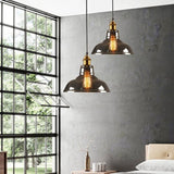 Two amber dome pendants lit in a bedroom beside a black framed window