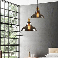 Two amber dome pendants lit in a bedroom beside a black framed window
