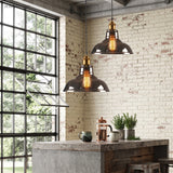 Two glass pendant lights above a concrete kitchen island beside a steel window