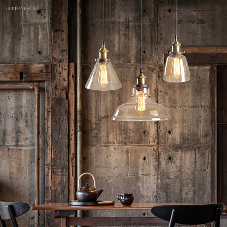 Three clear glass pendant lights above a rustic dining table and weathered timber