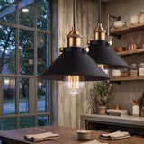 Two black cone pendants lit above a kitchen worktop by a window