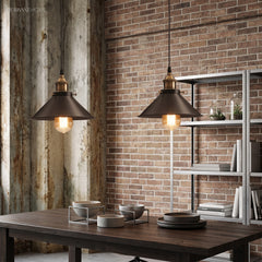 Two industrial pendants lit above a dark dining table and chairs
