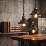 Three black cone pendants hung at staggered heights over a desk