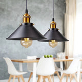 Two black cone pendants lit above a pale dining table and chairs