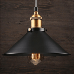 Single black cone pendant with an exposed bulb against dark timber