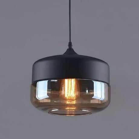 Amber drum shade with a black metal cap on a grey background
