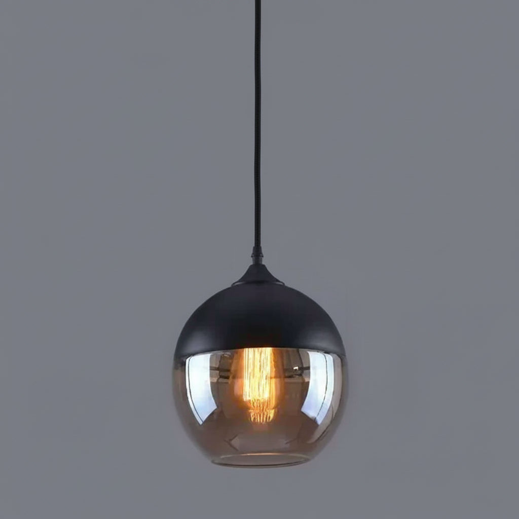 Amber glass globe shade lit warm against a grey background