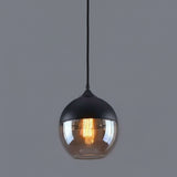 Amber glass globe shade lit warm against a grey background