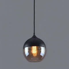 Amber glass globe shade lit warm against a grey background