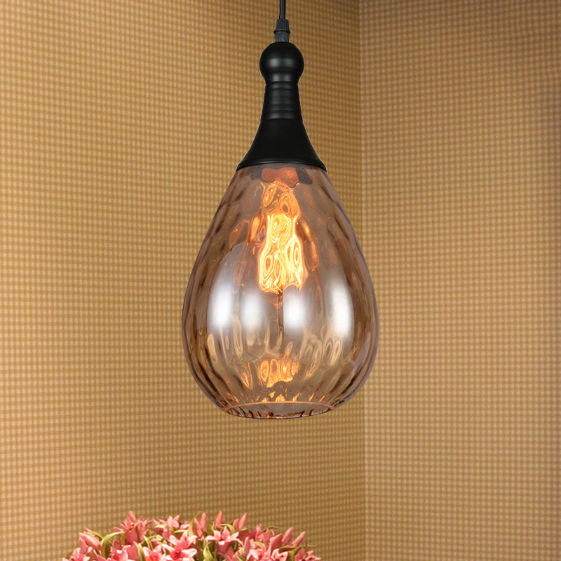 Amber teardrop pendant above pink flowers on a woven textured wall