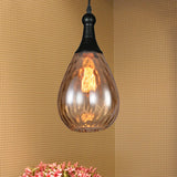 Amber teardrop pendant above pink flowers on a woven textured wall