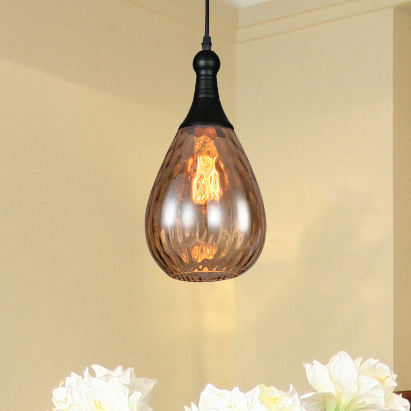 Amber teardrop pendant lit above a cluster of white flowers