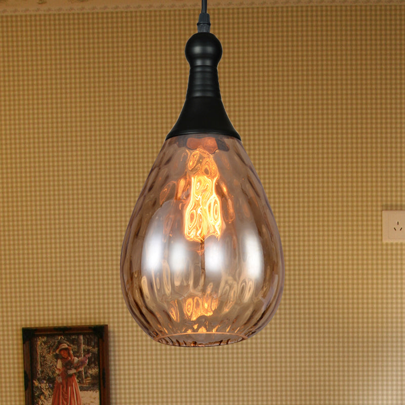 Amber teardrop pendant lit beside a framed picture on a woven wall