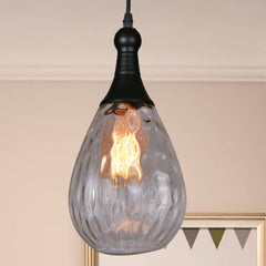 Clear dimpled teardrop pendant lit in a pale room with bunting