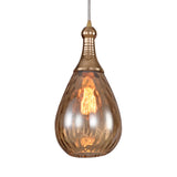 Brass capped teardrop pendant with a lit filament bulb on white
