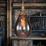 Brass capped teardrop pendant over a bench hung with hand tools