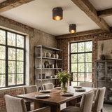 Two industrial flush mount ceiling lights above a rustic dining table