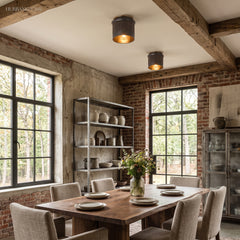 Two industrial flush mount ceiling lights above a rustic dining table