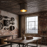 Weathered metal flush mount glowing above a reclaimed wood work table