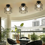 Three cage ceiling lights above a curved balcony with a planted tree