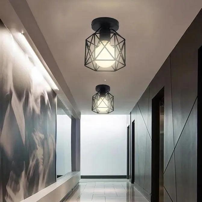Two caged ceiling lights lit along a dark modern gallery corridor