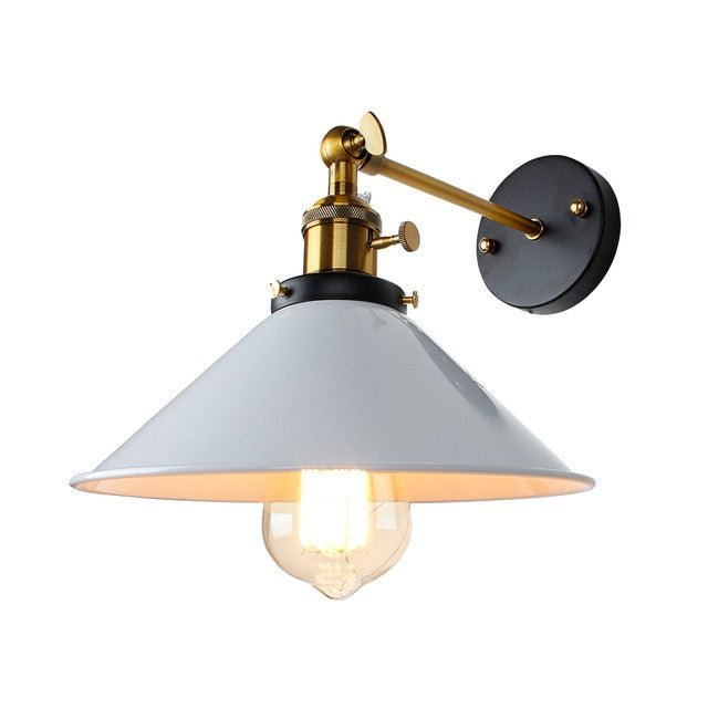 White cone shade sconce with an aged bronze arm and round backplate