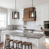 Two caged pendants with filament bulbs over a grey kitchen island