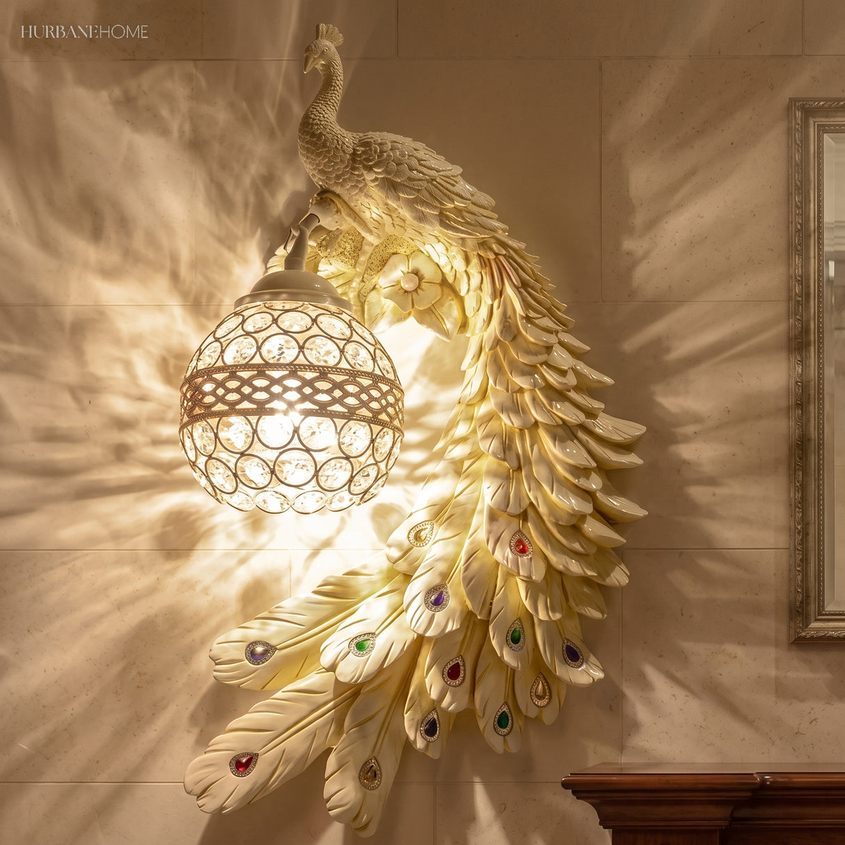 Ivory white peacock wall sconce mounted on a stone wall beside a gold frame