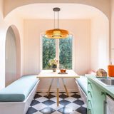 Amber glass pendant light over a pink breakfast nook with checkerboard floor
