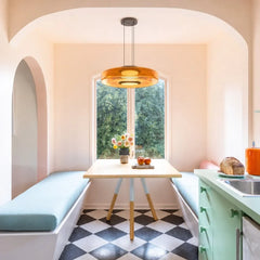 Amber glass pendant light over a pink breakfast nook with checkerboard floor