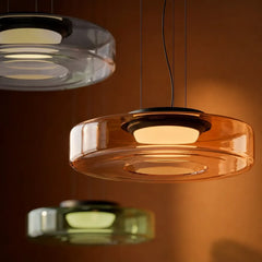 Amber two-layer glass pendant light lit against a warm brown wall