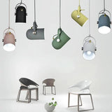 Seven pendant colours shown hanging together above modern chairs