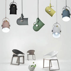 Seven pendant colours shown hanging together above modern chairs